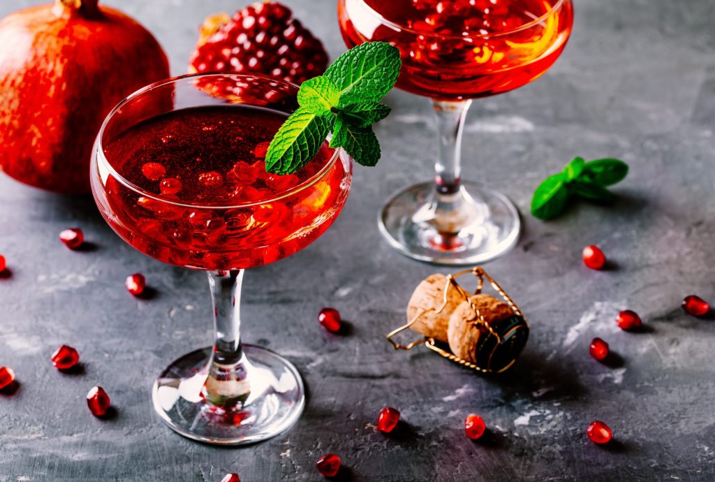 red cocktail with sparkling wine and pomegranate seeds
